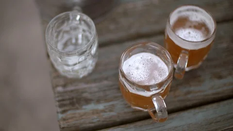 Slow tracking shot over the top of freshly poured beers on a pub garden table Stock Footage 87857714