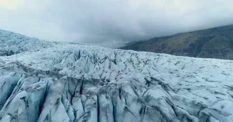 Slow tracking view of glacier chasms with dark overcast clouds Видео 79836837