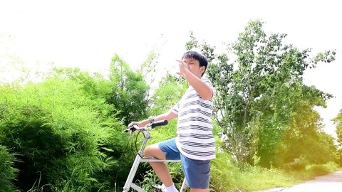 Slow two boy drinking water beside a bicycle Stock Footage 79588802