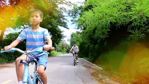 Slow two boy rid bicycle in the park Stock Footage 79588809