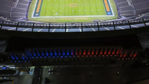 Slow upward tilt aerial of an empty, illuminated NFL stadium at night, Chicago Stock Footage 331215546