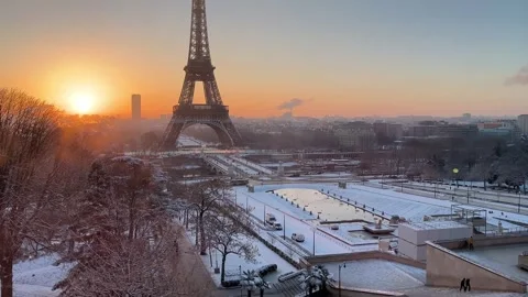 Slow upward tilt of the Eiffel Tower in Paris, France, above a snowy cityscape Vídeo Stock 334024175
