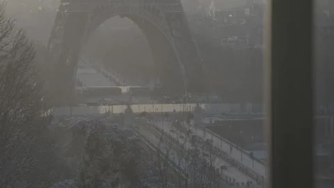 Slow upward tilt revealing the Eiffel Tower above a snowy Paris street, with Vídeo Stock 333676049