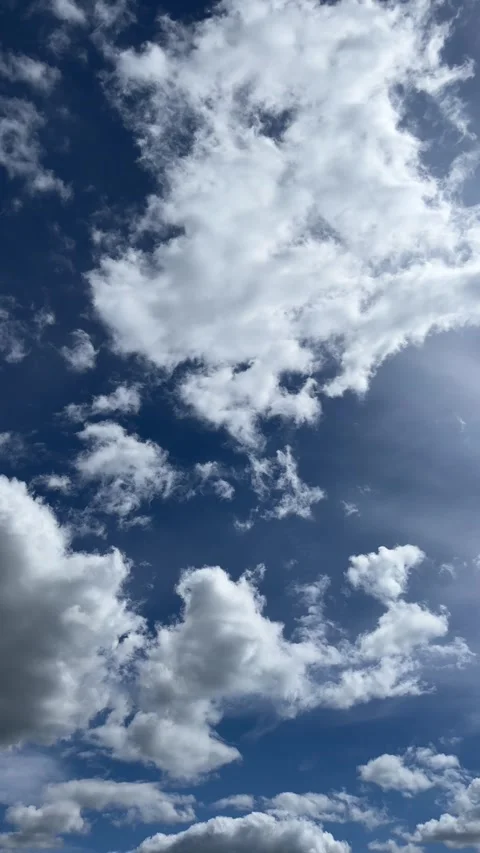Slow Vertical Shot of Cumulus Clouds on a Blue Sky Stock Footage 307743105