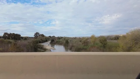 Slow View of Shallow River and Riparian Landscape While Driving on California Stock Footage 321099154