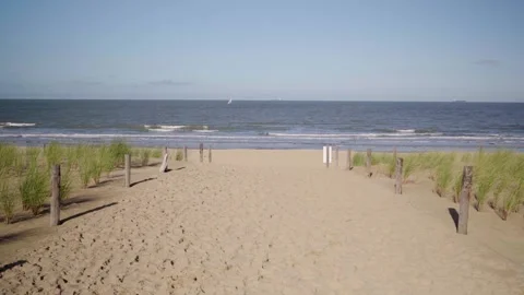 Slow walk towards sandy beach with sail boat and dune grass in Knokke Belgiu Video stock 329670371