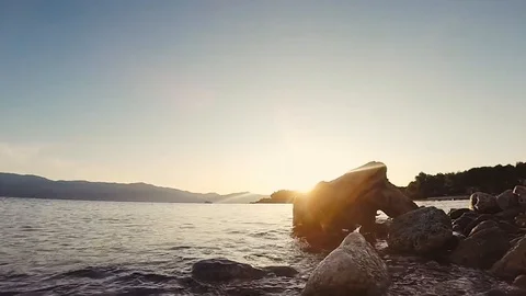 Slow waves on rocky beach during sunrise/sunset in Croatia Stock Footage 123012886