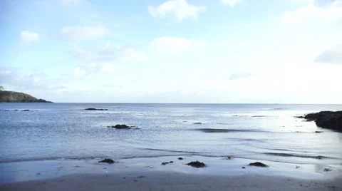 Slow waves rolling into a quiet bay on a sunny day Stock Footage 46532142