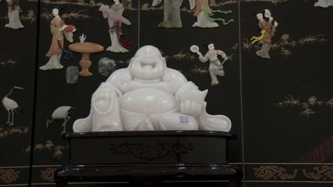 Slow zoom in to close of a white jade Chinese Buddha, 4K. Stock Footage 79704851