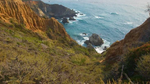 Slow zoom down a steep slope into the Blue Pacific Ocean waters at Big Sur Stock Footage 93706390