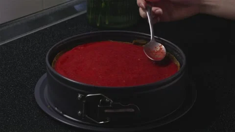 Slow zoom out of decorating cheesecake with red jam Stock Footage 340610732