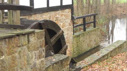 Slow zoom out of rotating wooden millwheel of an old water mill Stock Footage