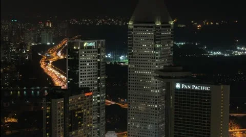 Slow zoom in over city buildings and busy roads at night. Singapore Time-lpase. Stock Footage