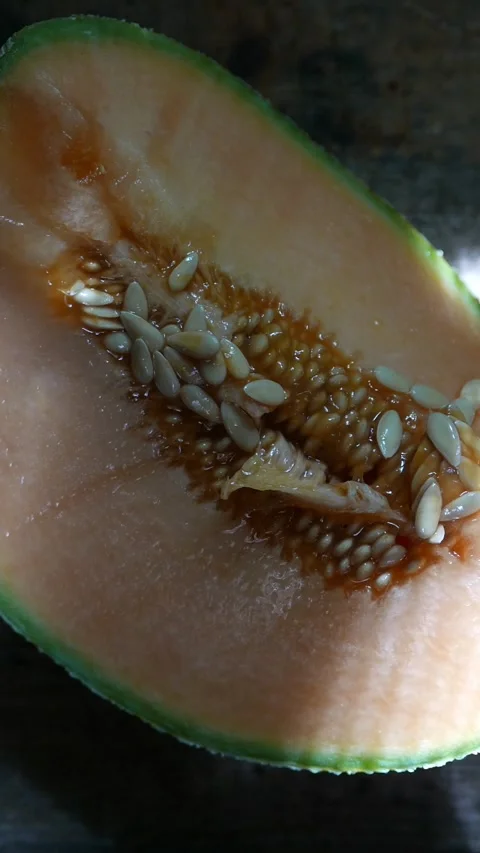 A slow zoom in reveals a slice of melon on the table. Close-up of melon seeds Stock Footage 309062528