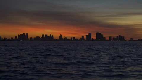 Slow zoom on vivid orange sunset settled over a panoramic Cityscape of Miami Stock Footage 102854980