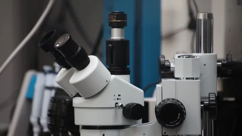 Slow zoom on white modern microscope in laboratory or industrial setting Stock Footage 102137588