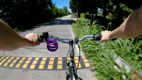 Slowing down on a bike before a speed bump on a rural road with trees pov Stock Footage 135572038