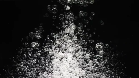 Slowly ascending bubbles in shining light Stock Footage 75813925