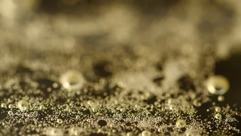 Slowly bubbling thick liquid. Close up handheld shot. Shallow depth of field. Stock Footage 168575745