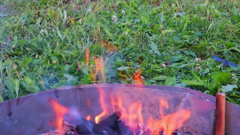 Slowly burning bonfire on a background of green grass. Downward camera movement Vídeo Stock 138826904