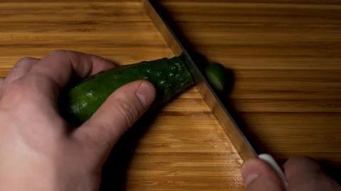  Slowly cuts the cucumber. Stock Footage 104657378