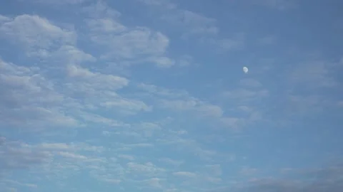 Slowly Drifting Wispy Clouds with Daytime Moon in Blue Sky Stock Footage 336872623