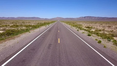 Slowly elevating shot over long straight road in desert Stock-Footage 92829003