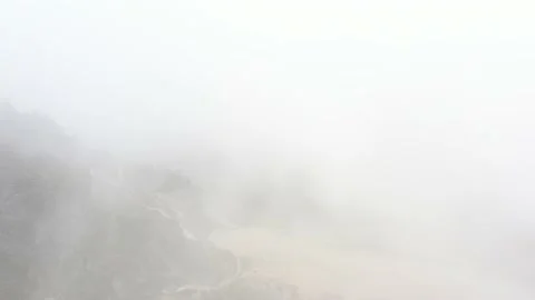 Slowly flying through spooky clouds showing small bits of the landscape Stock Footage 142755394