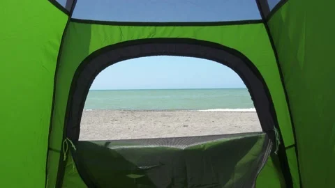 Slowly going away from inside of the camp tent to reveal a gorgeous sea view Stock Footage 159549482