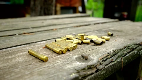 Slowly moving camera right to left and close up of empty bullet shells on table Stock Footage 311485221