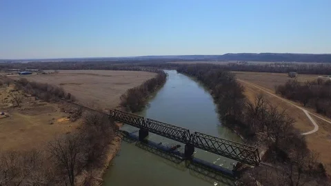 Slowly moving downstream tilting down over railway bridge Stock Footage 90258963