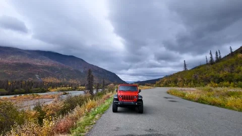 Slowly moving towards Red Jeep in scenic landscape of Alaska countryside. Stock Footage 320448218