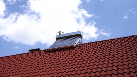 Slowly moving white clouds over the solar water heater boiler Stock Footage 313822083