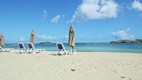 Slowly panorama at white sandy ocean shore with beach chairs and closed Video stock 130132977