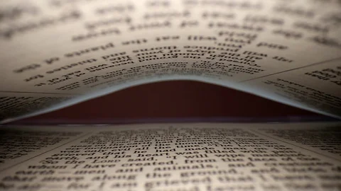 Slowly pulling lens out of a book at a words eye view of the pages, pages Stock Footage 111315070
