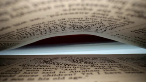 Slowly pulling lens out of a book at a words eye view of the pages, pages Stock Footage 111315114