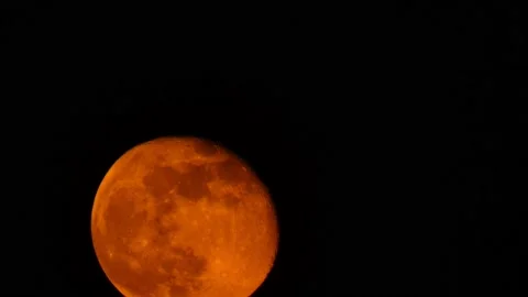 Slowly rising red moon close-up against the black night sky Stock Footage 171011697