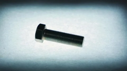 Slowly Rotating Metal Hex Bolt on Textured Surface Stock Footage 340069201