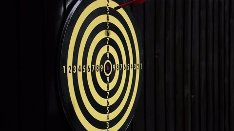 Slowly throw red and yellow darts at a dart board Video stock 159585048