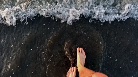 Slowly walking over the sand of a beach into the ocean Video stock 336934318