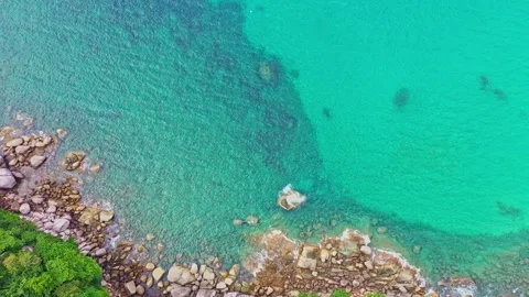 .slowly waves lapping on the rocky beach in a white foam wave. Stock Footage 253190376