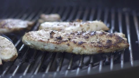 SLOWMO closeup pan of chared chicken grilling on a BBQ grill with smoke rising Stock Footage 91414670