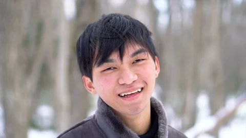 Slowmo - Happy Smiling Young Asian Man In Snowy Winter Forest Scene Stock Footage 100874062