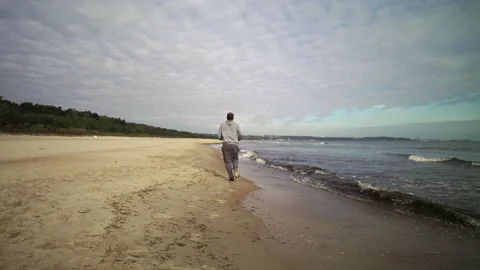 SlowMo: Man with Beard Running by the Beach at Dusk - Wide Shot Stock Footage 130730631