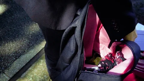 Slowmo - Man Packing Items into Backpack Stock Footage 98386747