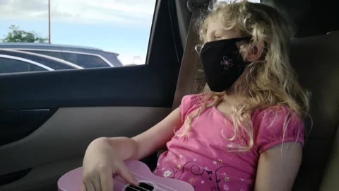Slowmo, Masked girl Playing Pink Ukulele in car Stock Footage