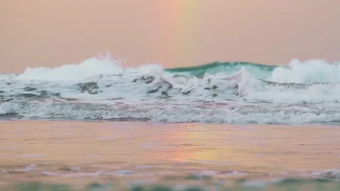 Slowmo of a rainbow reflecting on the surface of the sea in evening light Video stock 241013819