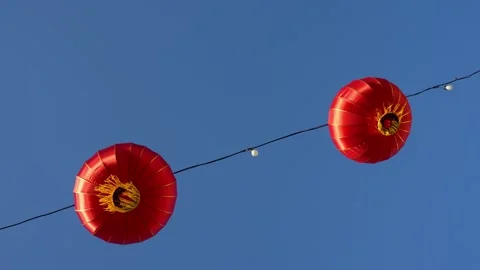 Slowmo red Chinese lanterns hanging on wire against blue sky Stock Footage 333033858