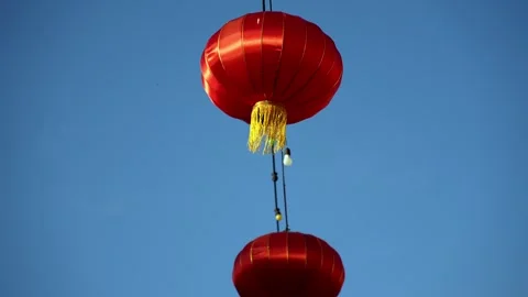 Slowmo red chinese lanterns hanging against clear blue sky Stock Footage 337730181