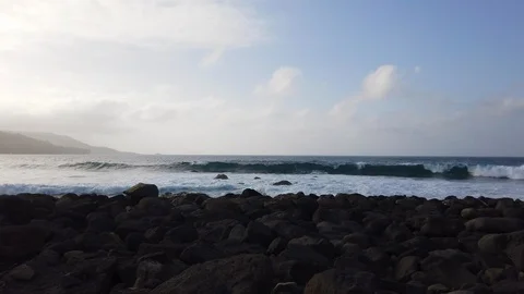 Slowmo Shot of Waves Crashing Through Beach on Rocky Shore Video stock 116109498